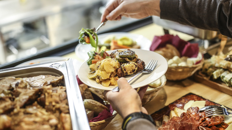 Diner filling a plate at a classic buffet