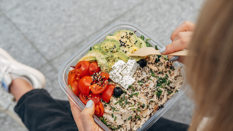A bird's eye view of a woman eating a chicken salad