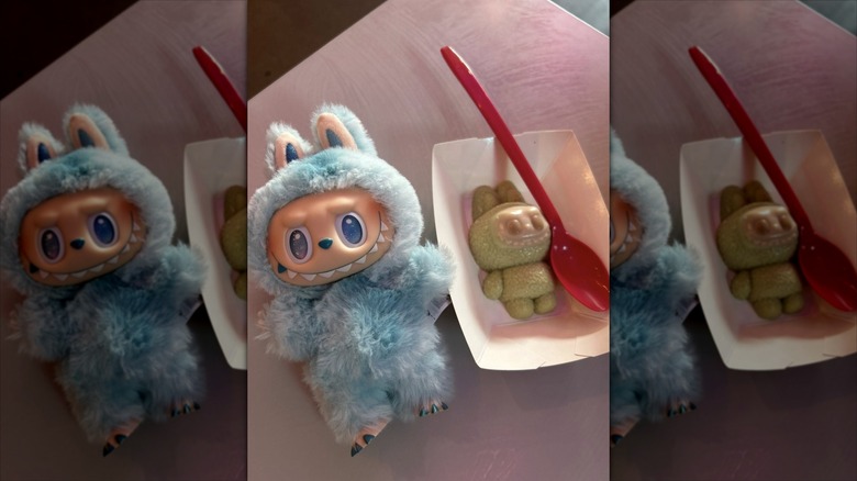 A Labubu plush sits next to a Labubu-shaped sweet