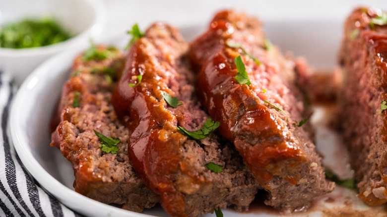 Sliced meatloaf on a white plate.