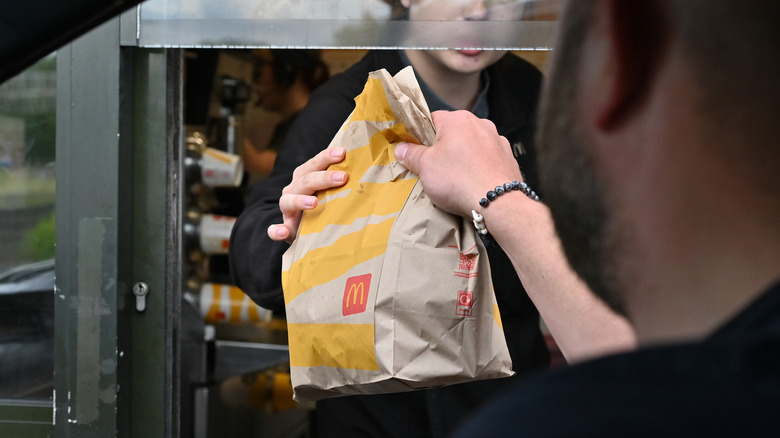 Customer picking up McDonald's drive-thru bag